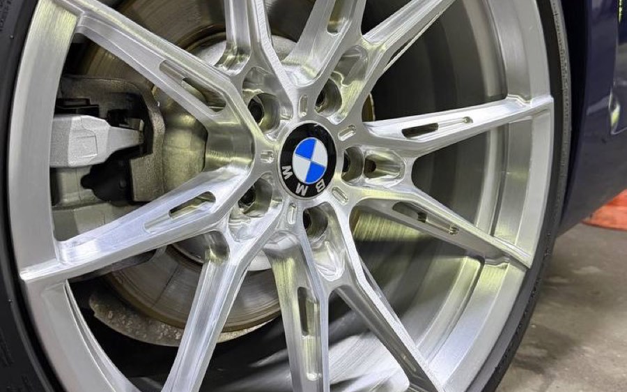 Кованый диск BMW крупным планом: полированные спицы, ступица и тормозной механизм