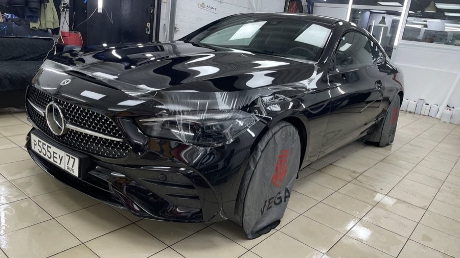 Чёрный Mercedes-Benz купе в процессе оклейки: плёнка на капоте, колёса в защитных чехлах